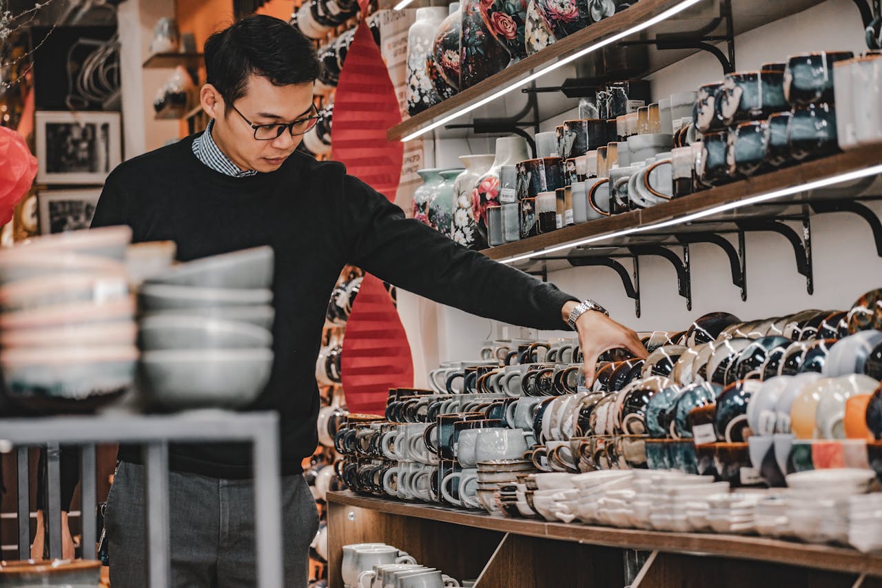 Friendly shop owner arranging products in a well-lit retail space